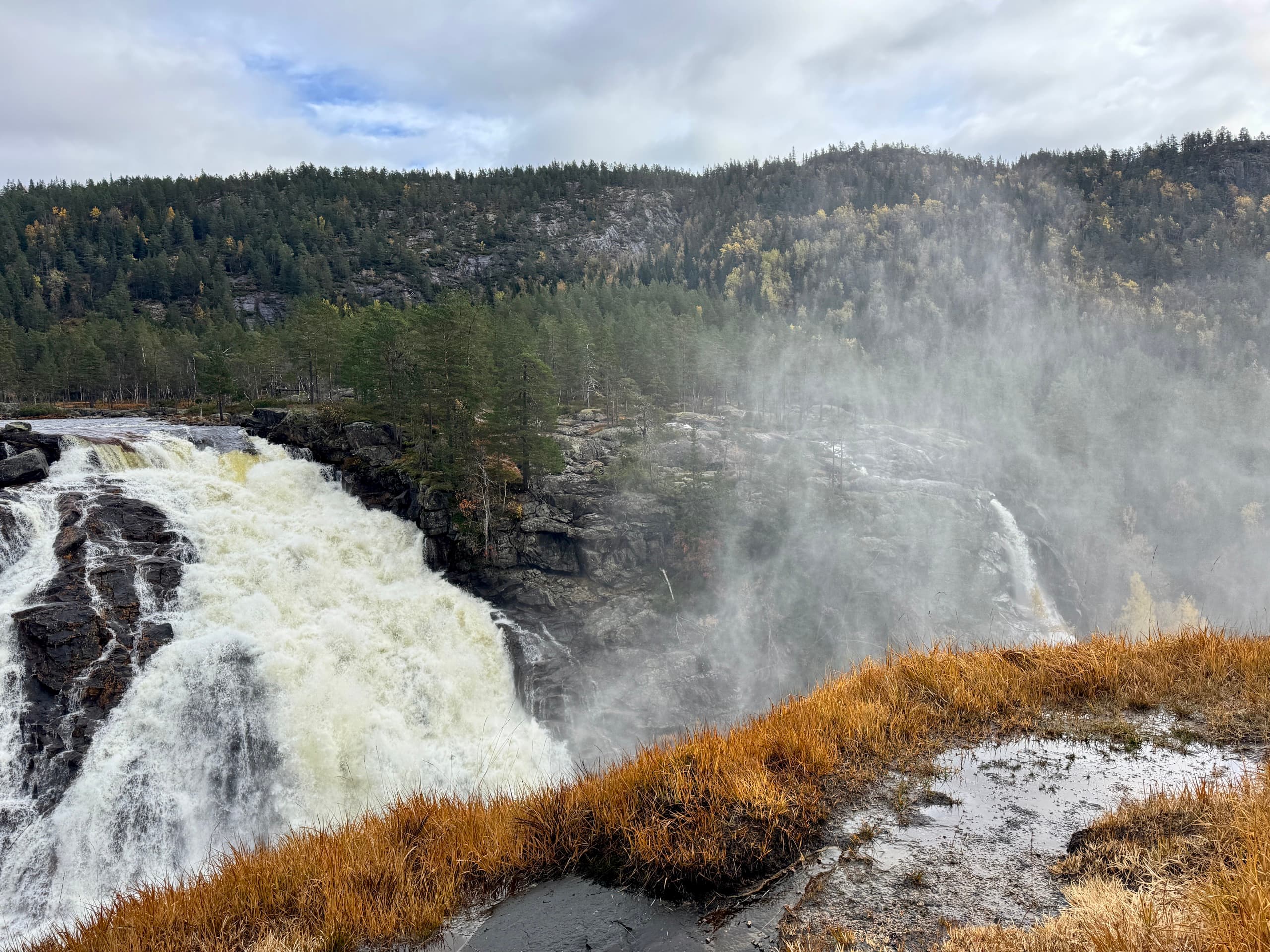 Stor foss med høstfarger i terrenget