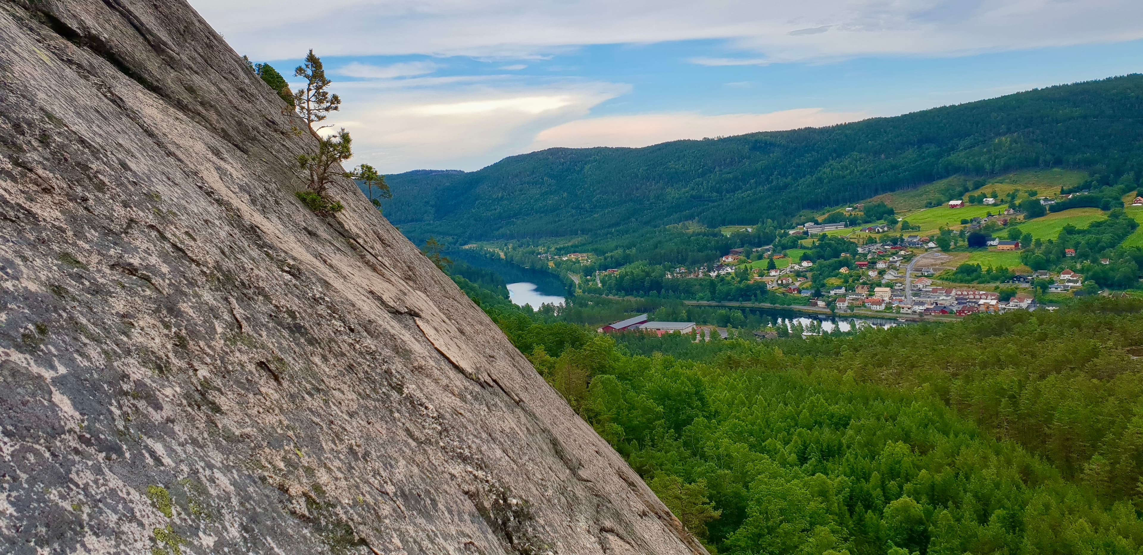 Utsikt fra klippekanten på via ferrata-ruta, ned mot dalen og vannet